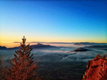 Scenic view of mountains against clear sky at sunset