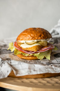 Large cheeseburger with chicken cutlet on a board close-up