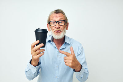Portrait of man using mobile phone against white background