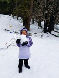 Full length portrait of boy standing on snow