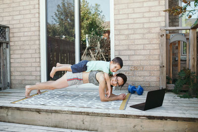 Side view of mother and daughter exercising outdoors