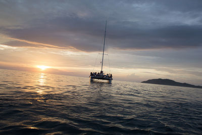 Boat sailing in sea at sunset