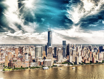 Aerial view of city buildings against cloudy sky