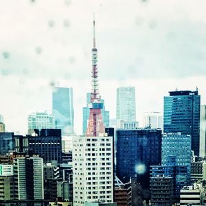 Modern buildings in city against cloudy sky