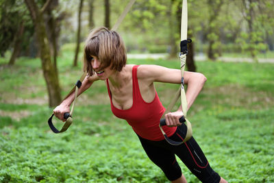 Mid adult woman exercising at public park