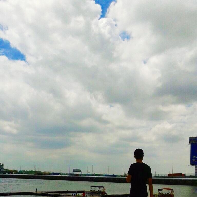 sky, cloud - sky, lifestyles, water, rear view, leisure activity, cloudy, men, standing, cloud, sea, railing, person, nature, weather, looking at view, river