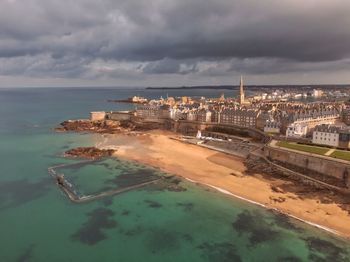 High angle view of cityscape by sea against sky