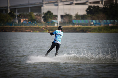 Rear view of man waterskiing in sea