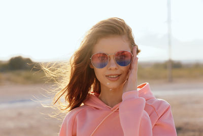 Portrait of young woman wearing sunglasses against sea