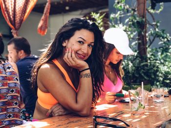 Portrait of smiling young woman sitting on table