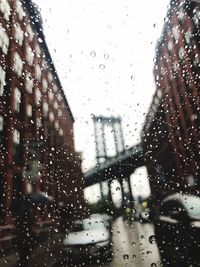 City seen through wet glass window during rainy season