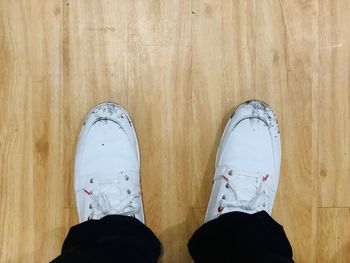 Low section of person standing on hardwood floor