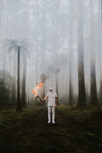 Digital composite image of woman standing in forest