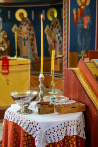 Close-up of lit candles on table at temple