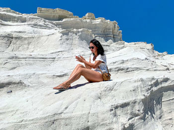 Young woman sitting on rock