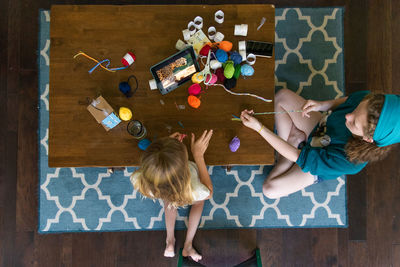 High angle view of girl sitting on table