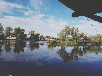 Scenic view of lake by trees against sky