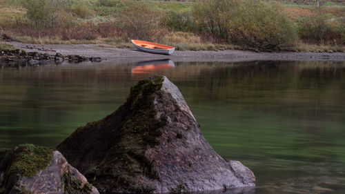 Boat on rock by lake