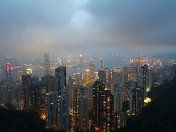 Illuminated buildings in city against sky