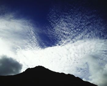 Scenic view of mountains against cloudy sky