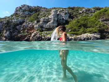 Full length of woman on rock by sea