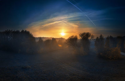 Scenic view of snow covered landscape against sky during sunset