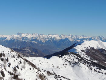 Scenic view of snowcapped mountains against clear blue sky