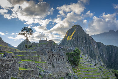 Castle on mountain against cloudy sky