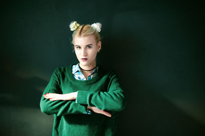 Portrait of young woman against black background