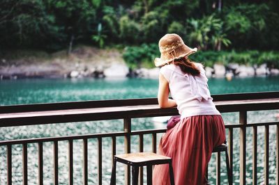 Rear view of woman standing by railing