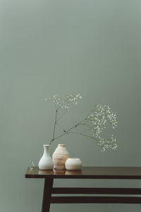 Minimalistic still life of ceramic dishes with flowers on table spring concept