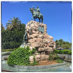 Low angle view of statue against blue sky