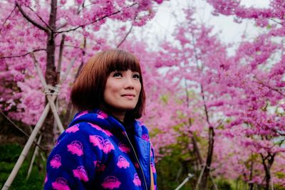 Portrait of woman amongst cherry blossom trees