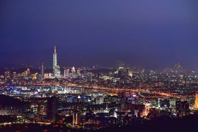 Illuminated cityscape against sky at night