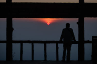 Rear view of man standing on railing