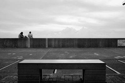 Rear view of man and woman against cloudy sky