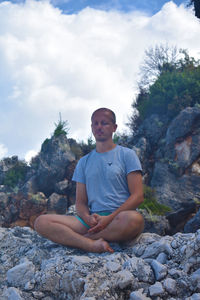 Portrait of young man sitting on rock