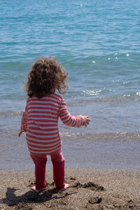 Rear view of girl standing on beach