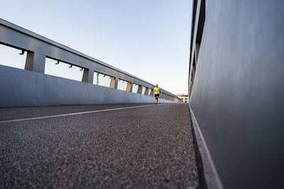 Man jogging on footbridge