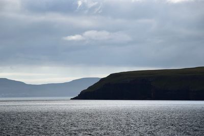 Scenic view of sea and mountains against sky