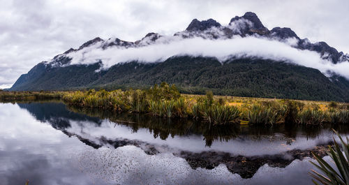 Scenic view of lake by mountains against sky