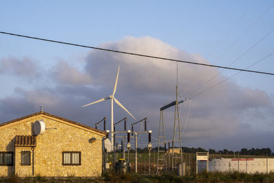 Low angle view of electricity pylons against sky