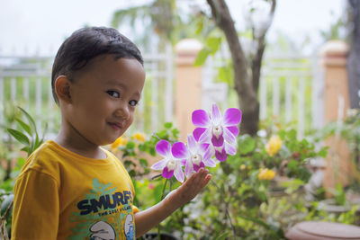 Portrait of cute boy touching flowers