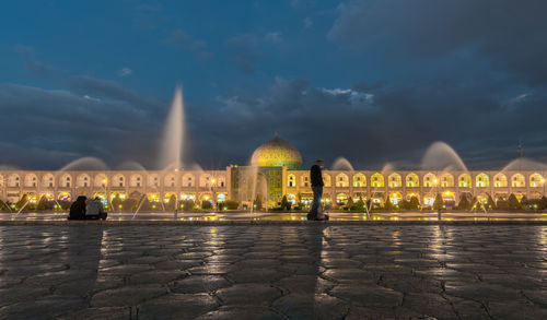 Illuminated mosque against sky at night