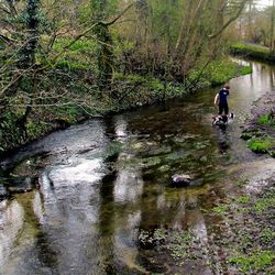 Man standing on footpath by river