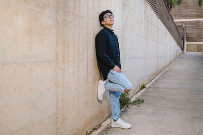 Confident transgender person posing standing outdoors on a walkway.