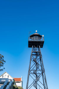 Low angle view of water tower against blue sky