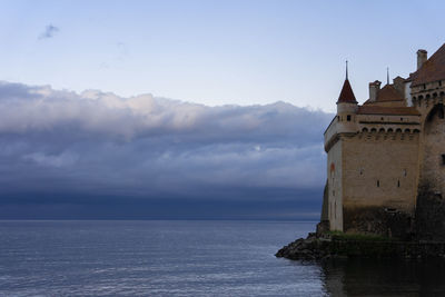 Building by sea against sky