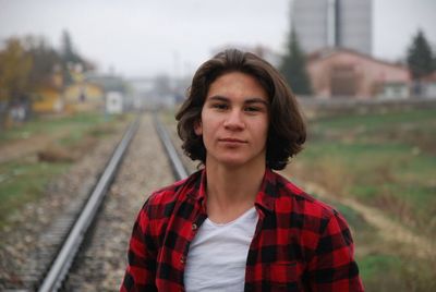 Portrait of mid adult man standing on railroad track