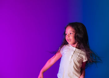 Low angle view of woman standing against pink wall